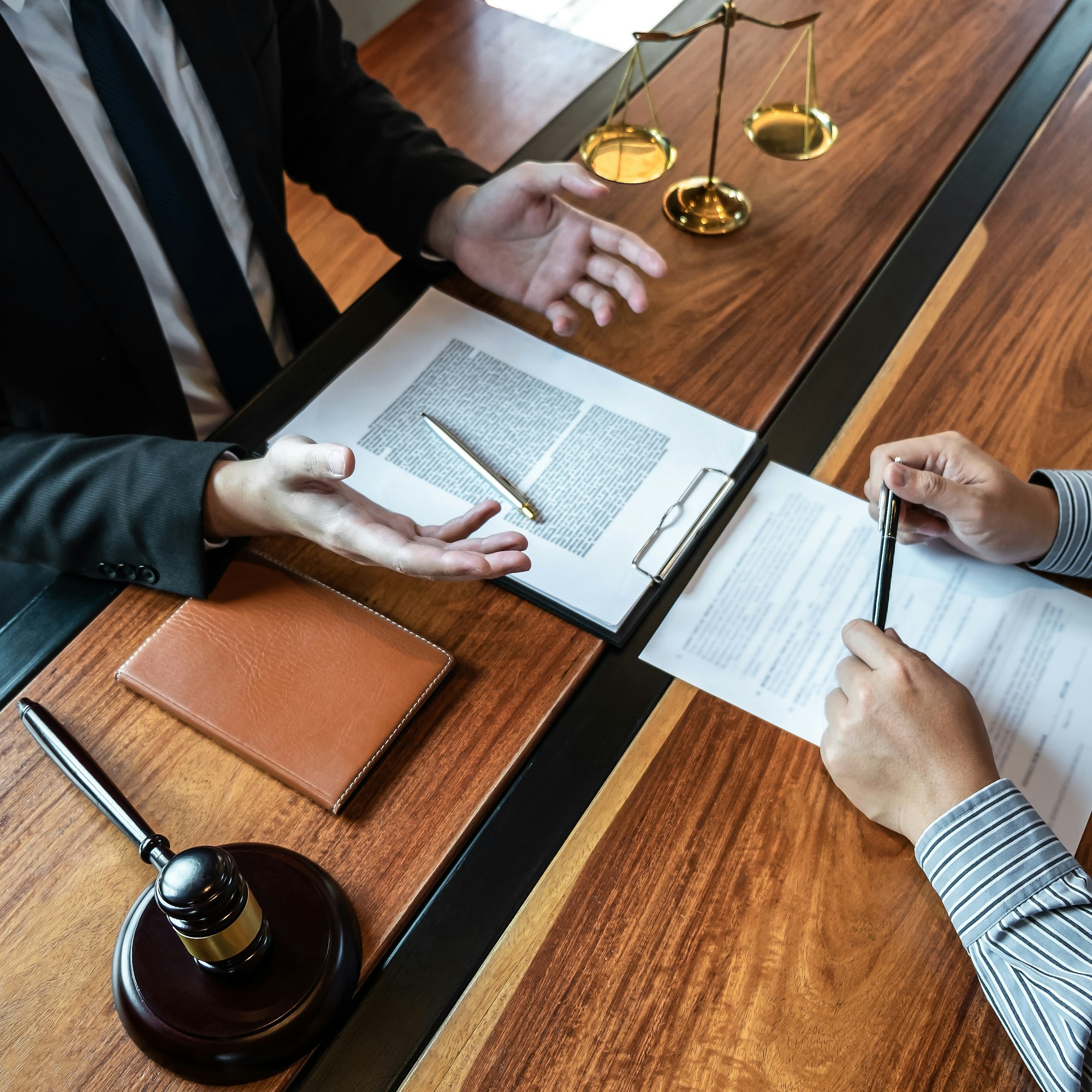 male lawyer discussing negotiation legal case with client meeting with document contract in office